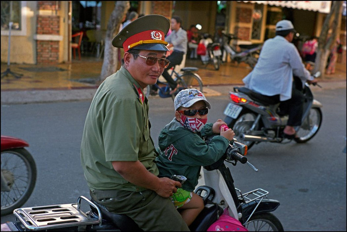 Một quân nhân và người cháu nhỏ trên đường phố ở Phong Điền. Ảnh: Ian Berry/ Magnum Photos.