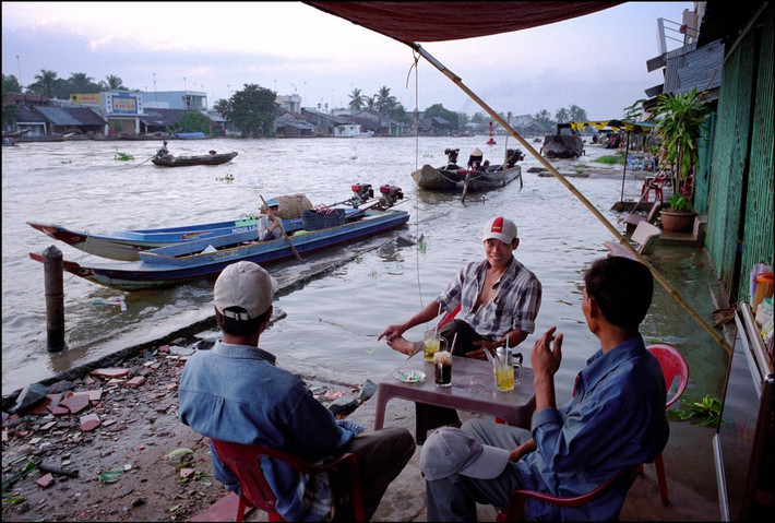 Quán cà phê bên sông lúc triều cường ở Phong Điền. Ảnh: Ian Berry/ Magnum Photos.