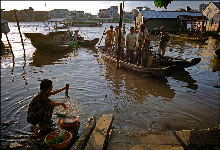 Người phụ nữ rửa rau tại một bến đò ở Phong Điền. Ảnh: Ian Berry/ Magnum Photos.