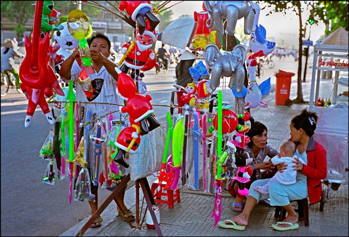 Quầy bán bong bóng bên vỉa hè ở Cần Thơ. Ảnh: Ian Berry/ Magnum Photos.