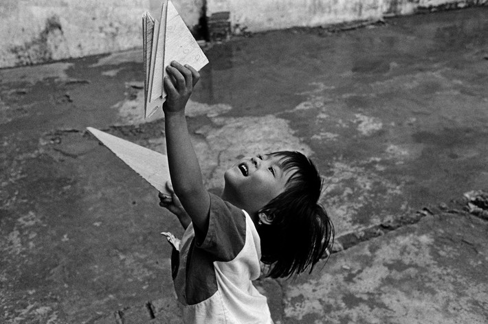 Em bé Sài Gòn chơi đùa trên vỉa hè. Ảnh: Ferdinando Scianna/ Magnumphotos.com.