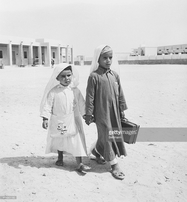 Trẻ em ở Doha đi trên con đường phủ cát để đến trường học năm 1961. Ảnh: Getty Images