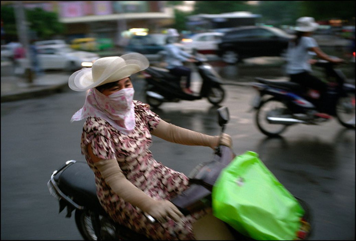 Người phụ nữ đội chiếc mũ thời trang khi lái xe máy. Ảnh: Ian Berry/ Magnum Photos.
