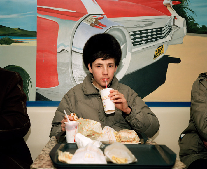 Một thanh niên thưởng thức đồ ăn Mc Donalds. Ảnh: Martin Parr/ Magnum Photos.