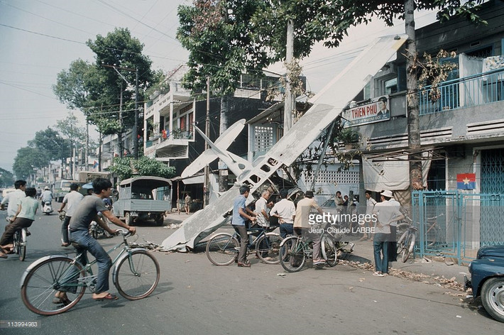 Hiện trường vụ máy bay rơi ở Sài Gòn năm 1975 trong ảnh của Jean-Claude Labbe. Dù rơi giữa trung tâm thành phố nhưng chiếc máy bay không gây thương vong cho dân thường do kích cỡ nhỏ và không xảy ra cháy nổ khi rơi.
