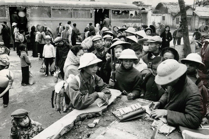 Cảnh bán vé xe khách ở Hà Nội sau kỳ nghỉ Tết năm 1967. Nhiều trẻ em được đưa về ăn tết tại Hà Nội sẽ theo các chuyến xe trở về vùng sơ tán tại nông thôn. Ảnh: Lee Lockwood.