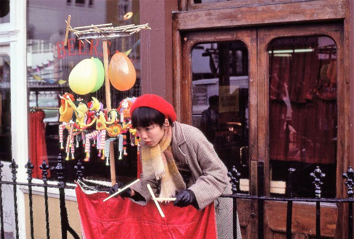 Ngườ phụ nữ biểu diễn múa rối dạo bên ngoài quán rượu Earl of Lonsdale ở phố Portobello, 1980. Ảnh: Glen Fairweather.