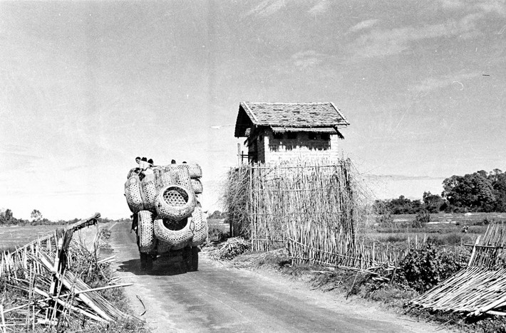 Chiếc xe khách chở đầy giỏ tre đi qua một tháp canh trên ở Tây Ninh năm 1950. Ảnh: Harrison Forman.