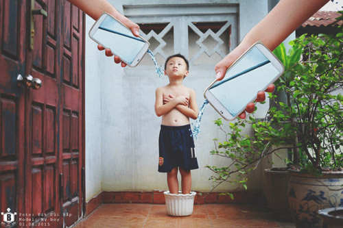 Sự vô tình đó đã, đang và làm những đứa trẻ xa dần với cuộc sống thực, suốt ngày chìm đắm bên chiếc điện thoại thông minh và sống ảo với những điều nó nghĩ. Ảnh: “Và như vậy, đứa bé lớn lên như một hạt giống, được tưới tâm hồn từ những chiếc smartphone. Nhưng hãy nhìn vẻ mặt của đứa trẻ, đôi tay thân hình của đứa bé. Đôi mắt vô hồn không sức sống, đôi tay bé nhỏ ôm lây thân hình không đủ dưỡng chất, thể chất”.