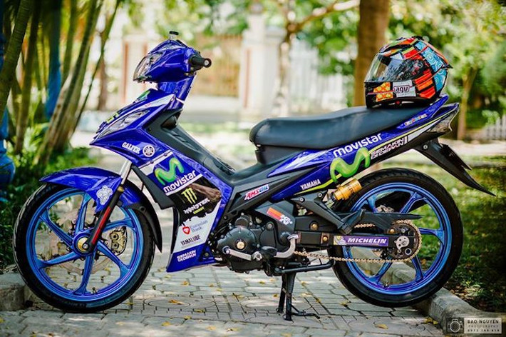 Cũng giống như Exciter 135, mẫu xe 2 kỳ Yamaha 125ZR có "tuổi đời" khá lâu nhưng tới hiện nay, dòng xe này vẫn được sản xuất tại Malaysia và vừa có phiên bản đặc biệt Movistar MotoGP. Để "làm mới" lại chiếc Exciter 135 của mình, một biker trẻ người Nha Trang đã dọn lại chiếc xe theo phong cách độ kiểng với chi phí thấp bằng dàn tem đấu Movistar giống Yamaha 125ZR 2017 bản đặc biệt.