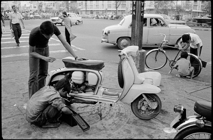 Sửa xe máy ở giao lộ Nguyễn Huệ - Lê Lợi. Ảnh: Magnumphotos.com.