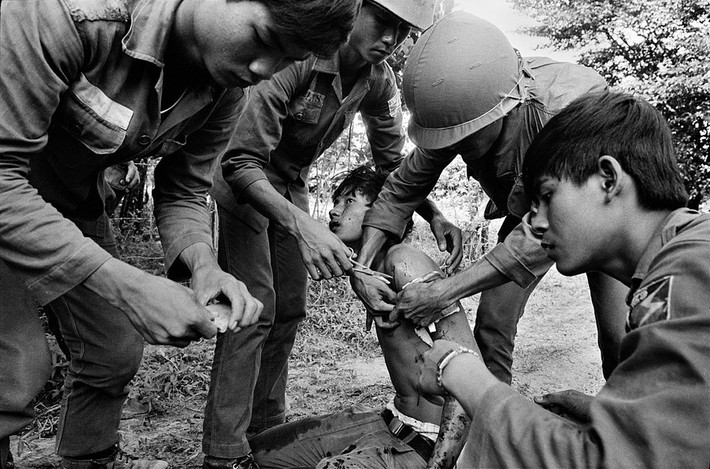 Sơ cứu cho một binh sĩ bị trúng đạn ở cánh tay. Ảnh: Magnumphotos.com