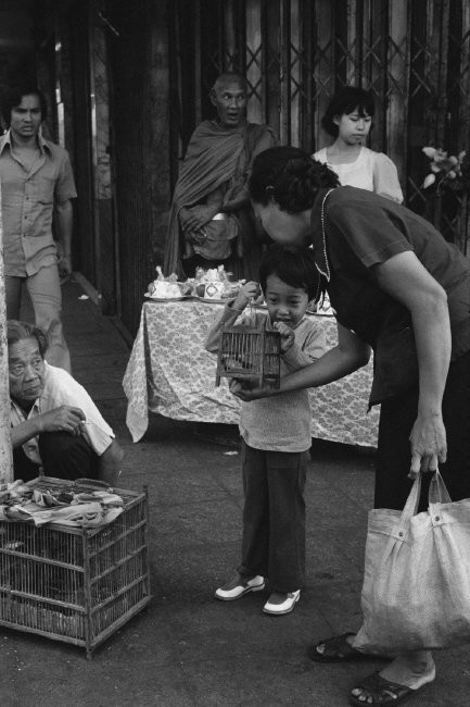 Hai mẹ con và lồng chim phóng sinh bên ngoài một ngôi chùa. Ảnh: Hiroji Kubota/ Magnum Photos.
