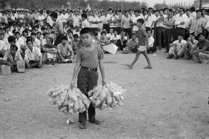 Cậu bé bán hàng rong tại một sự kiện văn hóa diễn ra ngoài trời. Ảnh: Hiroji Kubota/ Magnum Photos.