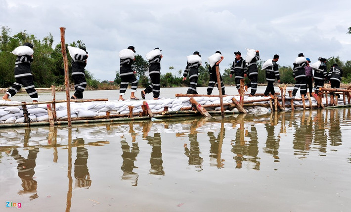 "Chúng tôi đã dồn hơn 20.000 cát để vá đoạn đê sạt lở. Hiện tại anh em chiến sĩ tiếp tục khiêng, chèn ở vị trí xói lở khoảng 6.000 bao cát nữa mới có thể ngăn dòng tạo lối đi tạm cho người dân", chiến sĩ Hà cho biết.