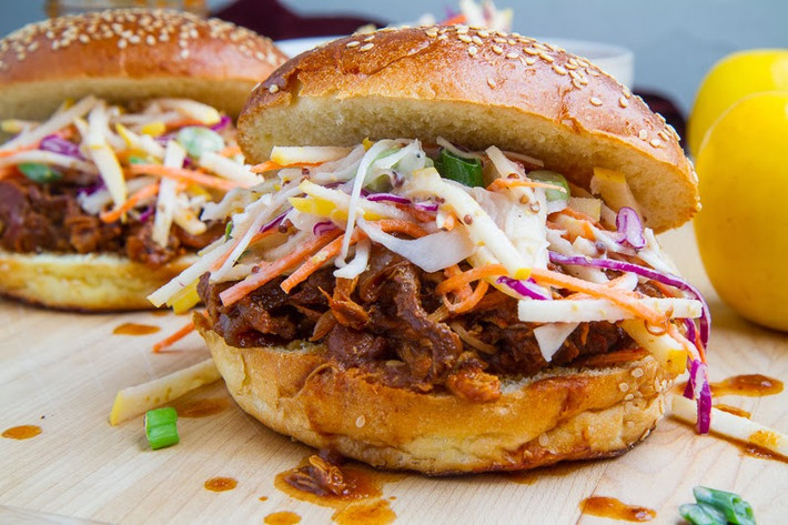 Gà hầm còn khoảng 30 phút cuối, chúng ta quay ra làm món rau trộn. Cho dấm gạo, đường, tương ớt Sriracha, dầu mè vào bát to trộn đều rồi cho xà lách, bắp cải vào xóc. Đậy nắp lại và để tủ lạnh khoảng 30 phút cho ngấm, thỉnh thoảng xóc lên cho đều.