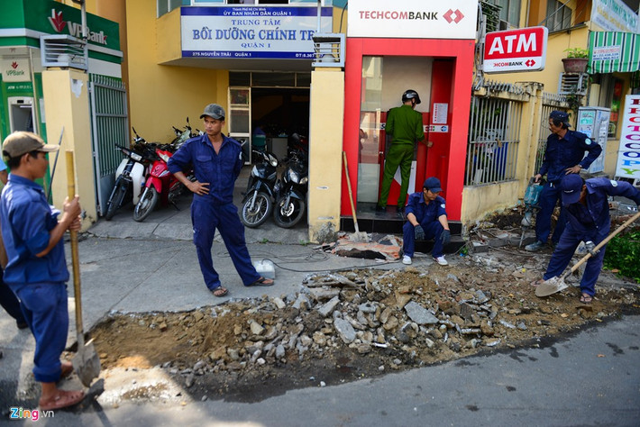 Trước cửa Trung tâm Bồi dưỡng chính trị của quận, công nhân tiếp tục phá dỡ nền xi măng bị bong tróc, sau đó sẽ tráng lớp bê tông mới.