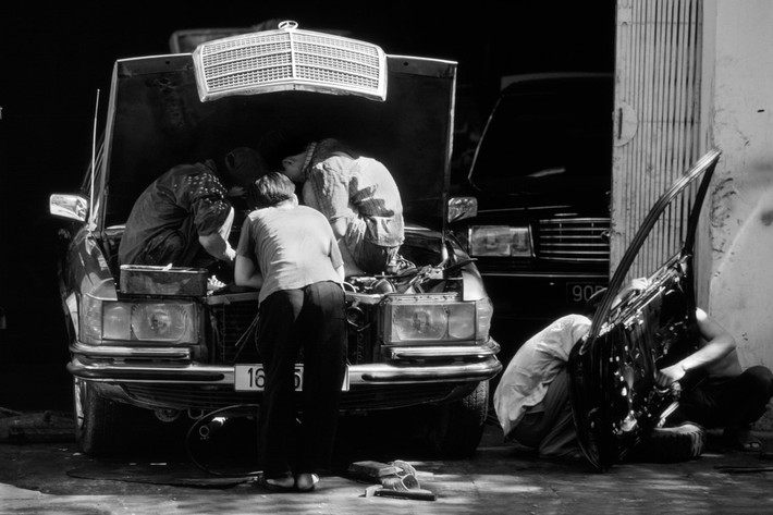 Một chiếc Mercedes trong xưởng sửa chữa xe hơi, 1997. Việc sở hữu xe hơi cá nhân bắt đầu xuất hiện ở Hà Nội thập niên 1990. Ảnh: Philip Jones Griffiths / Magnum Photos.