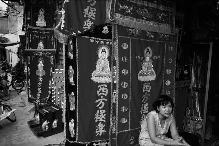 Cửa hàng bán đồ thờ ở phố Hàng Quạt, 1997. Ảnh: Philip Jones Griffiths / Magnum Photos.