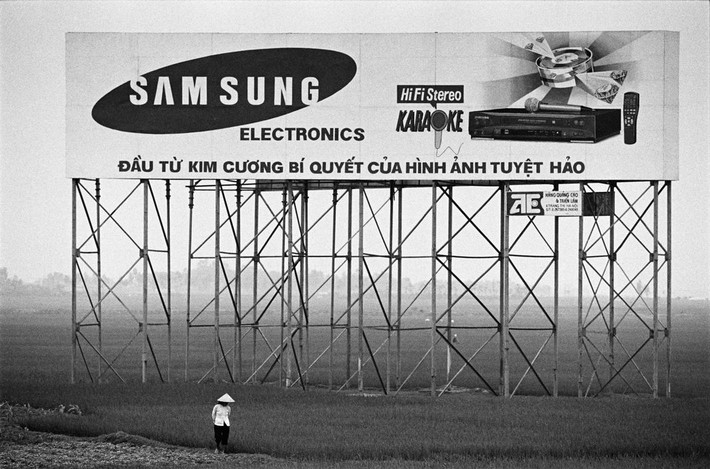 Pa-nô quảng cáo của hãng Samsung trên ruộng lúa ở ngoại thành Hà Nội, 1999. Ảnh: Philip Jones Griffiths / Magnum Photos.
