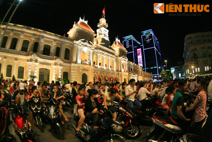 Trên đường Lê Thánh Tôn, phía trước UBND TP HCM, hàng trăm người ngồi trên xe máy để chờ đón pháo hoa.