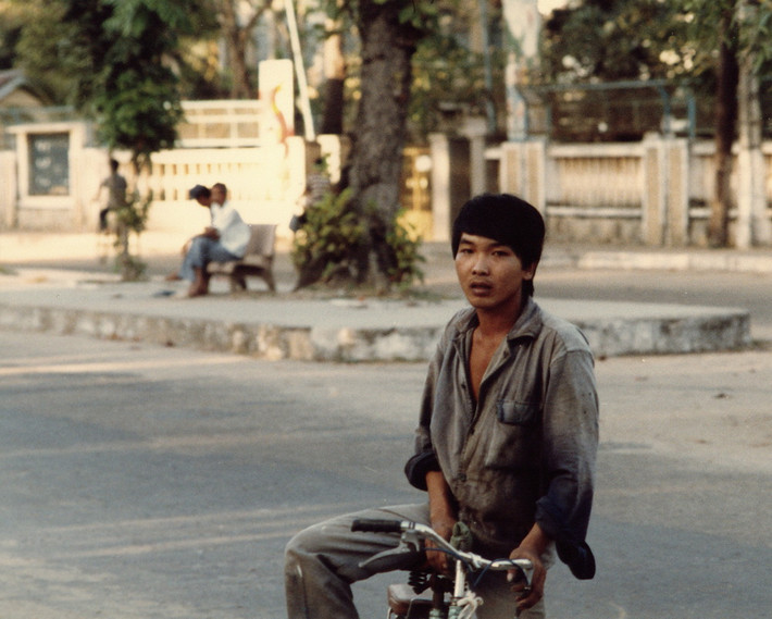 Dáng vẻ phong trần của một thanh niên đi xe đạp.