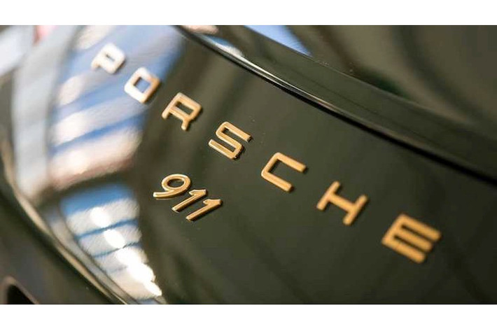Thay vì có đầy đủ dòng chữ "911 Carrera S" ở phía sau đuôi xe như phiên bản thường, chiếc 911 thứ 1 triệu chỉ có logo nổi 911 nằm bên dưới dòng chữ Porsche. Những chữ cái và con số này đều được mạ vàng, nổi bật trên nền xanh lá của chiếc xe.