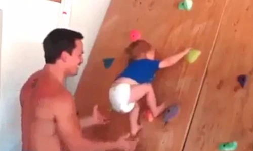 Ông bố chơi ngông cho con trai bé nhỏ leo tường