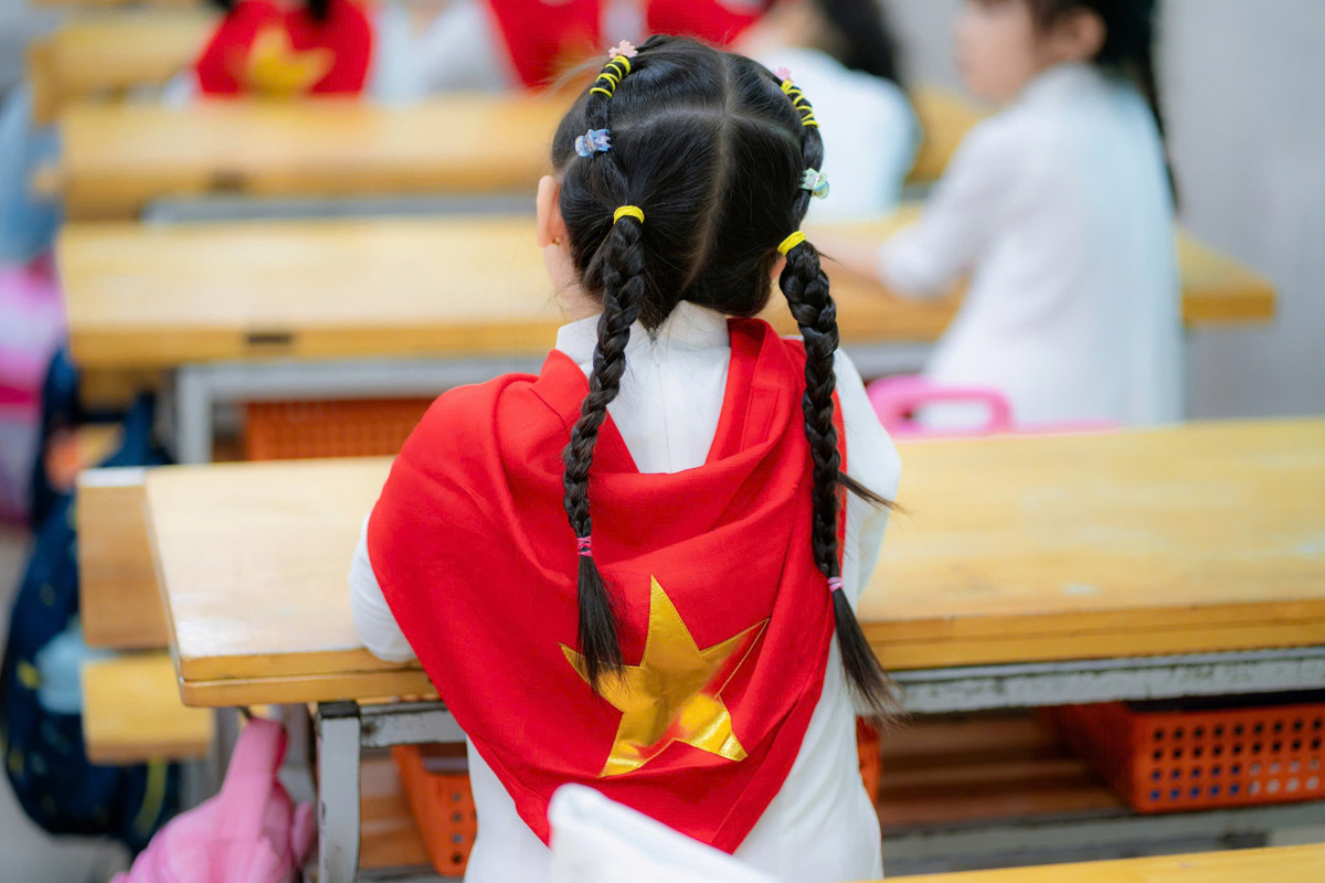 Những chiếc khăn quàng in hình cờ đỏ, sao vàng được các em nhỏ khoác lên mình đầy tự hào.