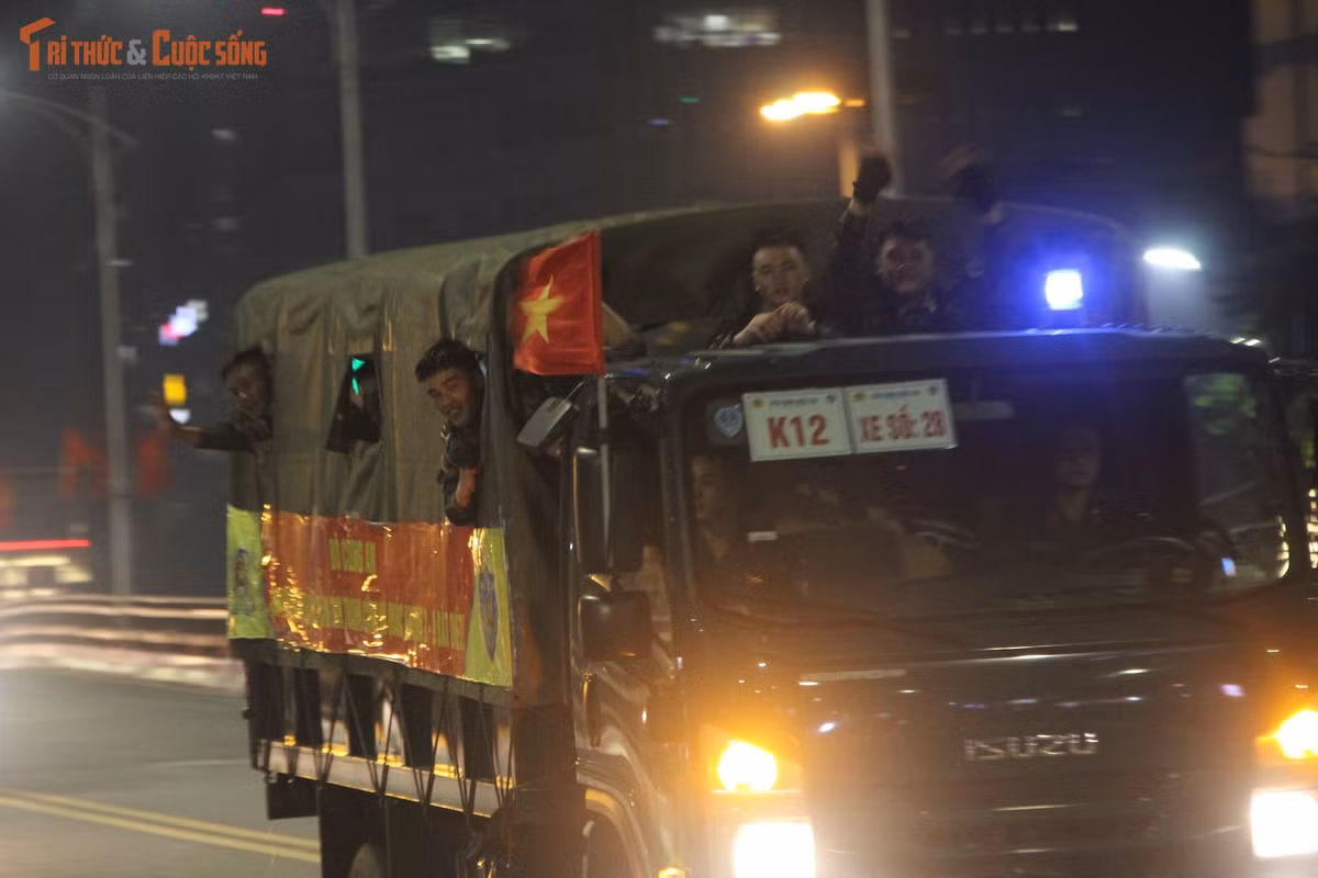 Nhiều chiến sĩ hào hứng chào tạm biệt với người dân đứng hai bên đường trong đêm muộn.