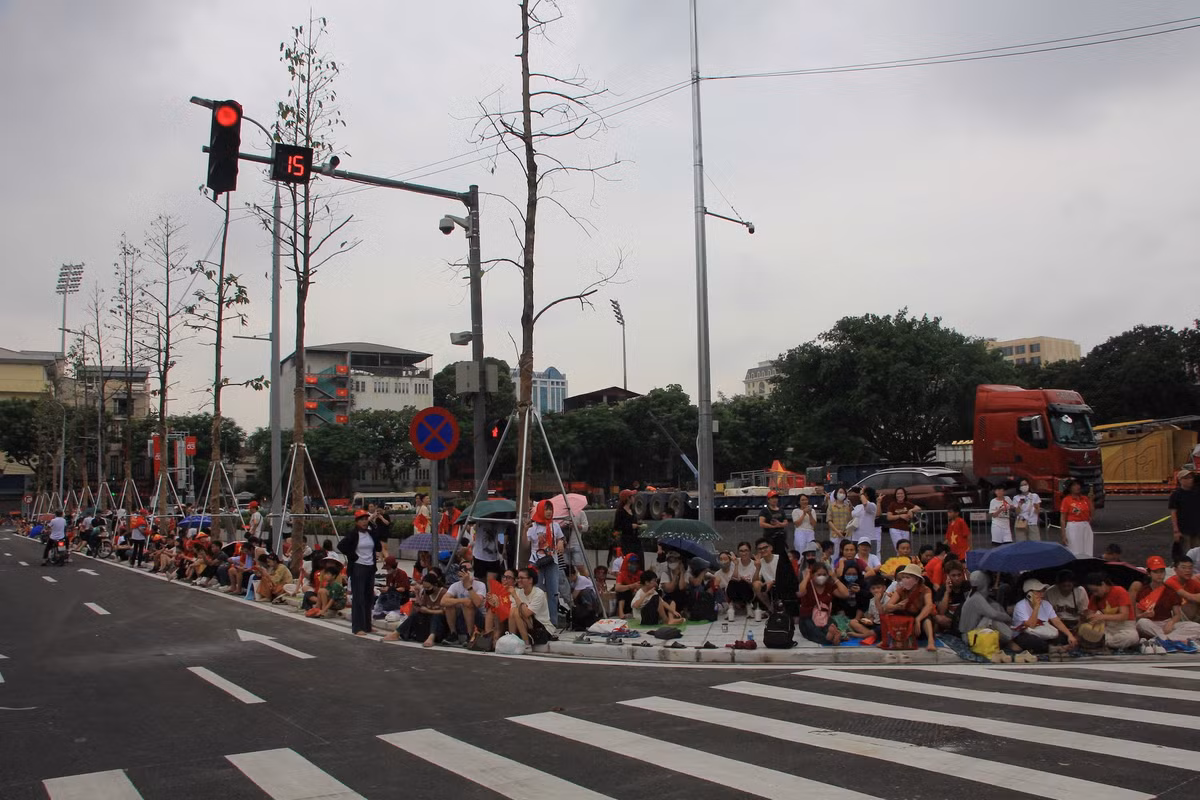 Dọc vỉa hè ngã tư Hùng Vương - Nguyễn Thái Học đã đông kín người dân xếp hàng ngồi chờ buổi hợp luyện.