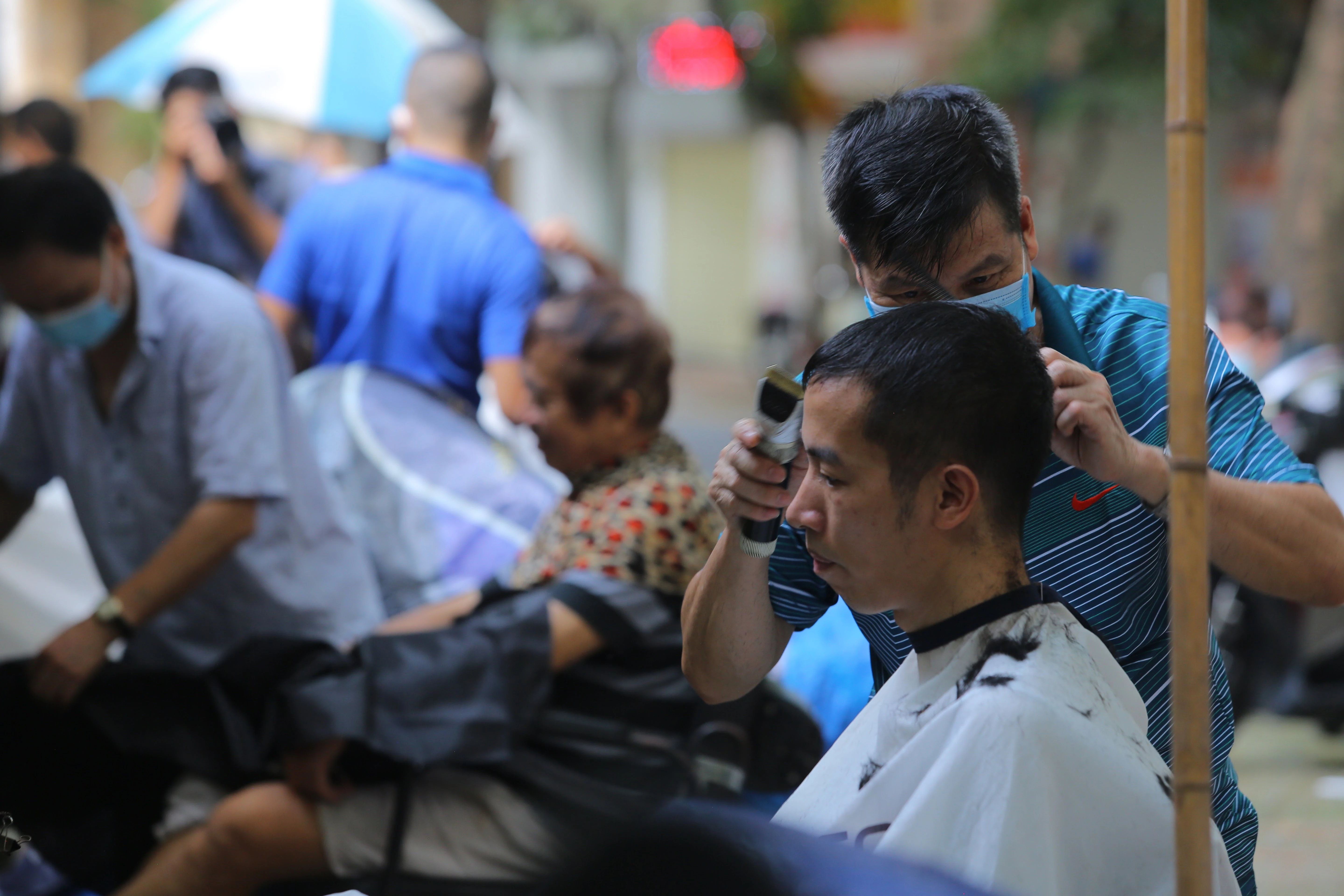 Cắt tóc vỉa hè nườm nượp, khách xếp hàng chờ tới lượt từ sáng sớm