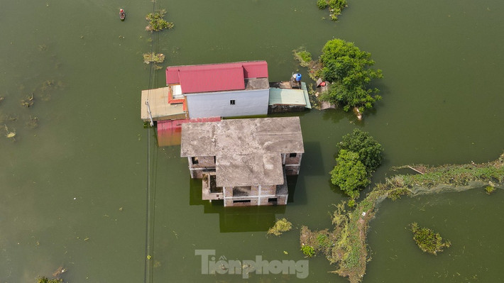 Thôn Phú Hiền nằm dọc hai bên bờ sông Mỹ Hà, nhiều nhà dân nước ngập cao, tầng 1 chìm nghỉm trong nước.