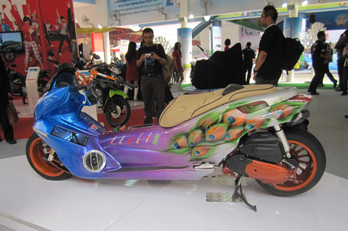 Xe ga Honda PCX ở Việt Nam ít được các dân chơi độ lại. Nhưng dòng xe này lại là thú chơi đầy cá tính của nhiều người đam mê xe trên thế giới. Một bản độ PCX đầy ấn tượng với bộ tem hình con công và bánh xe màu cam nổi bật. Thân xe được kéo dài, thách thức các tay chơi điều khiển.