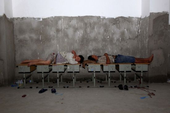 Một số người khác lại kê những chiếc bàn học sinh để làm giường ngủ.