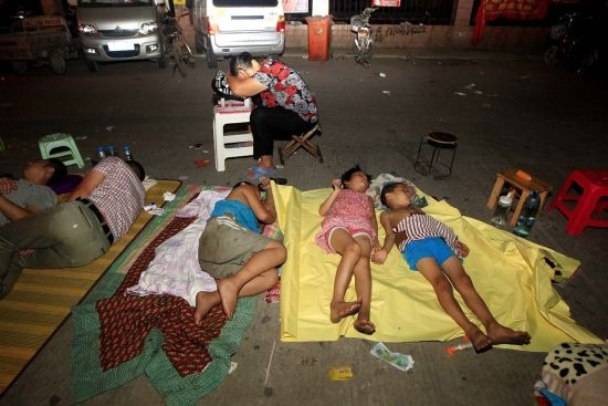 Cảnh trẻ em và người lớn nằm ngủ vạ vật ở ngoài đường để chờ xin nhập học bên ngoài một trường tiểu học ở thành phố Trịnh Châu, Trung Quốc.