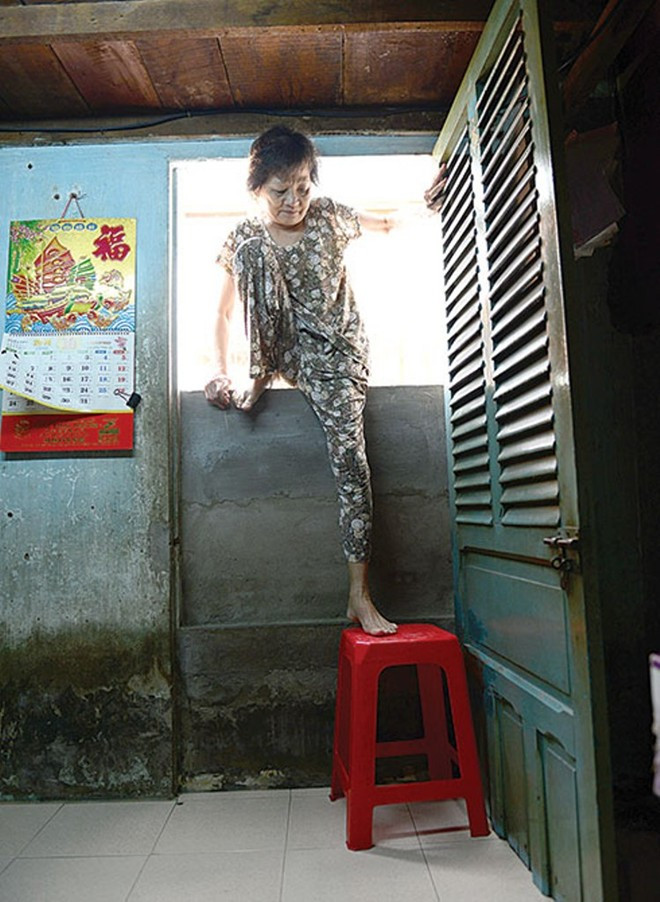 Họ ra vào nhà bằng cách chui, bò, bắc thang, kê ghế nhựa bên trong. Bà Nguyễn Thị Hoài đặt ghế nhựa ngay cửa để lên xuống nhưng vẫn rất thấp so với mặt đường.