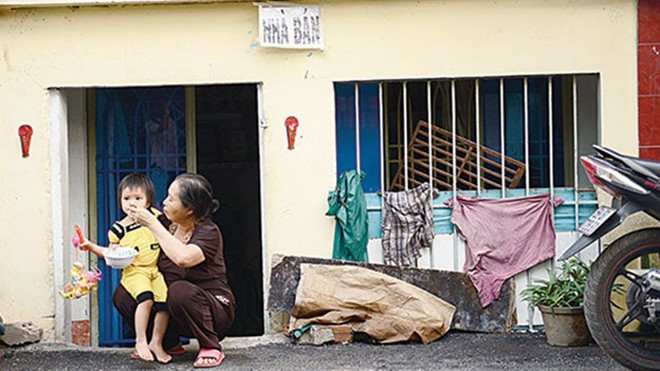 Hai bà cháu bà Phạm Thị Tỵ, nhà số 17 lô C đường Phạm Văn Chí, quận 6, TP HCM trước ngôi nhà đang rao bán của mình.