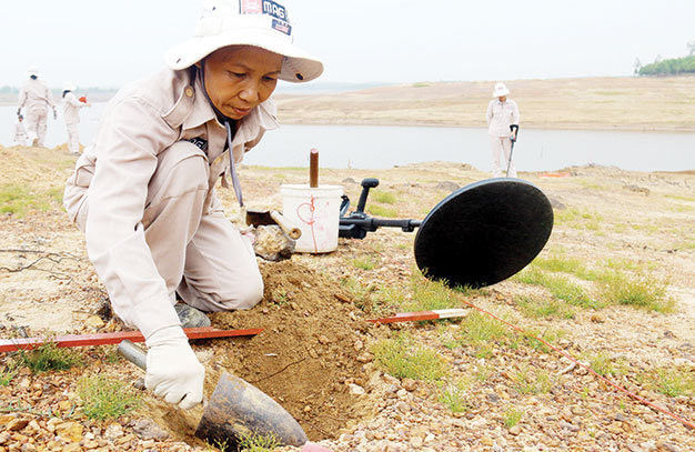 Chị Hoàng Thị Hải Lý đào tìm bom bi sau khi máy dò báo tín hiệu.