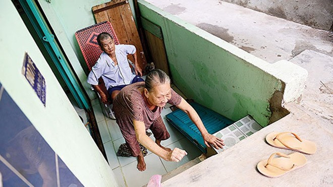 Có những gia đình không chịu đựng nổi phải bỏ hoang hoặc rao bán căn nhà mới xây của mình với giá rẻ. Còn những người ở lại cắn răng chịu đựng cuộc sống ngột ngạt và khổ sở. Bà Lý Thị Ba (70 tuổi) bị tai biến chín năm nay, phải bò từ nền nhà lên mặt đường ở hẻm 1007 Lò Gốm, quận 6, TP HCM.