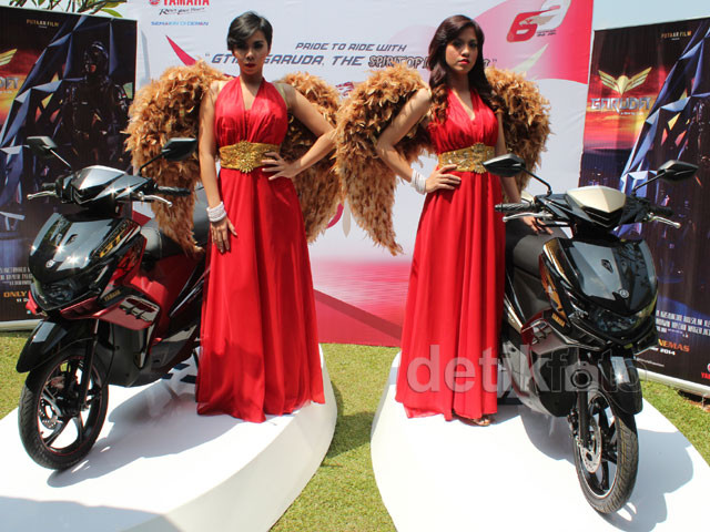 Người mẫu nóng bỏng trong đầm đỏ và mang cánh chim Garuda giới thiệu 2 phiên bản xe Yamaha GT125 mới.