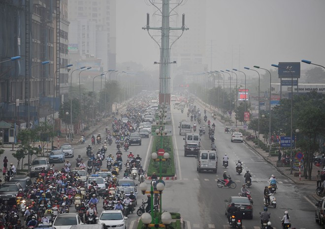 7h30 sáng tại đường Tố Hữu, các phương tiện thấp thoáng trong làn sương trắng đục.