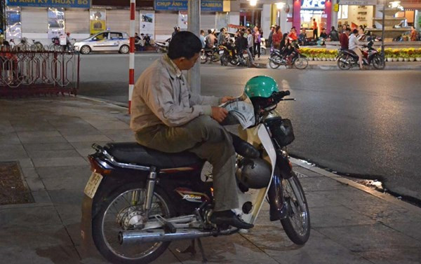 Những người lái xe ôm đợi khách trong đêm gió mùa.