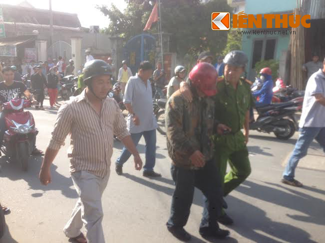 Khoảng gần 1 tiếng sau, sau khi nghe thượng tá Trịnh Văn Sâm, đội trưởng đội CSĐT quận 9 thuyết phục, đối tượng Long đã bỏ mã tấu, đồng ý để thượng tá Sâm vào trong. Ảnh chụp đối tượng Long (mũ đỏ) được thượng tá Sâm khoác vai đưa ra ngoài mà không cần còng tay trong tiếng reo hò của người dân. Sau đó, Long được đưa lên xe để về trụ sở công an quận.