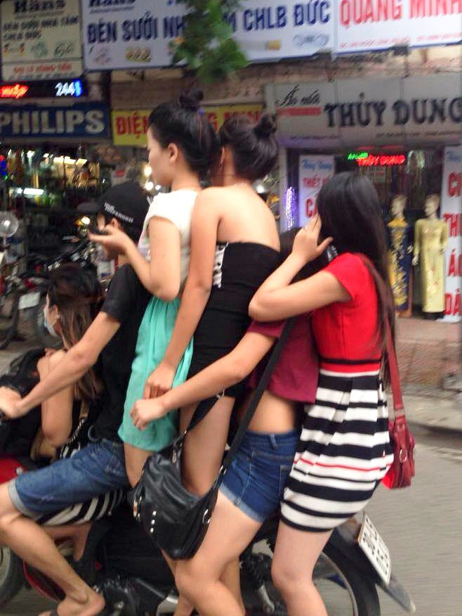 Một xế ôm đội mũ mềm kẹp thêm 5 cô gái ăn mặc hở hang, đứng cả lên xe máy phóng tốc độ cao khá nguy hiểm.