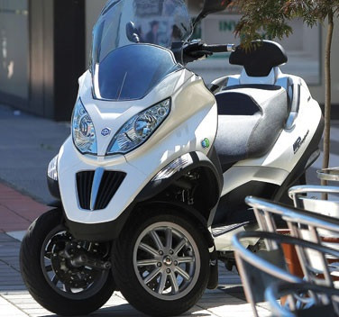 Piaggio MP3 300 2015 gây ấn tượng với kính chắn gió màu xám, đèn xi nhan mới và dải 7 đèn LED chiếu sáng ban ngày.