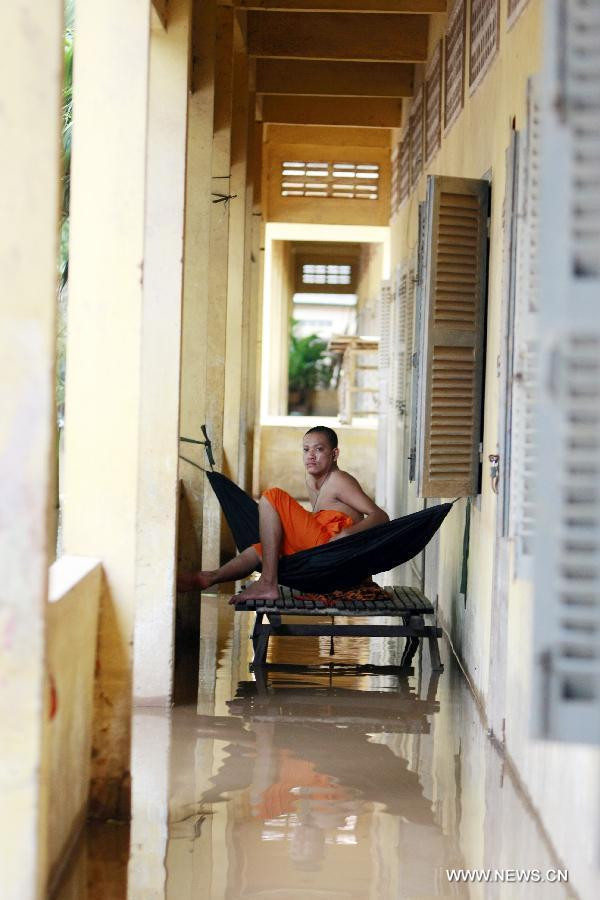 Nhà sư mắc võng trên hành lang ngập nước của một ngôi chùa ở tỉnh Kandal.