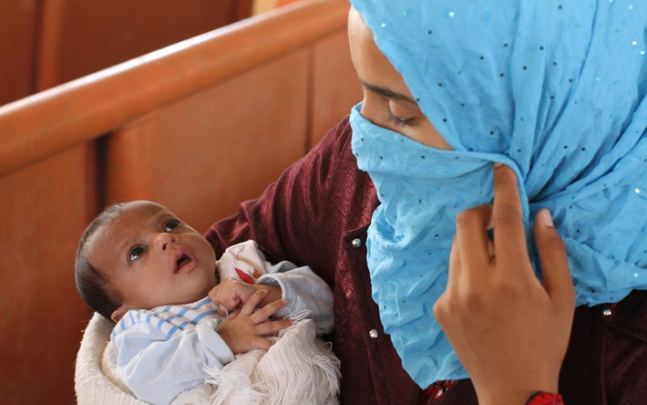 Một bà mẹ bế con con 2 tháng tuổi trong trại tị nạn Zaatari.