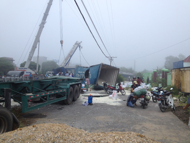 Vụ tai nạn khiến 2 toa tàu số 1 và số 2 bị lật văng khỏi đường ray, xe container bị kéo vỡ nát.