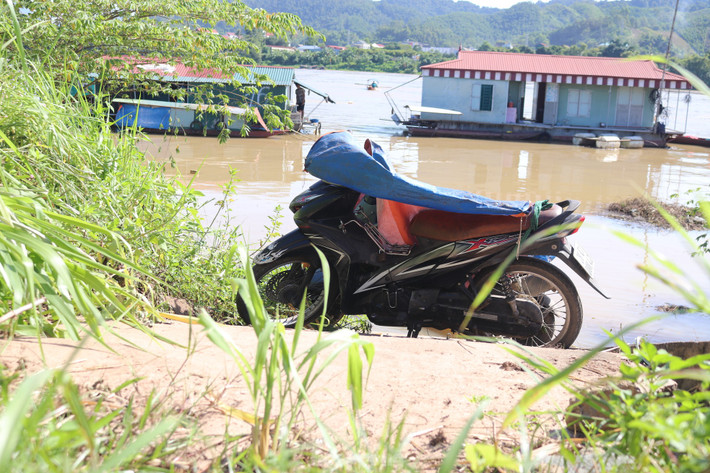 Nơi để xe bị ngập, người dân phải dựng xe trên đường đê và che chắn sơ sài bằng những chiếc bạt.